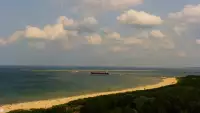 Kamery nad morzem na szeroką plażę i falochrony w Świnoujściu.