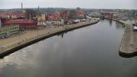 Widok z pylonu na plażę, latarnię morską i kanał portowy.