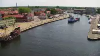 Widok z pylonu na plażę, latarnię morską i kanał portowy.