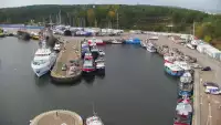 Widok z pylonu na plażę, latarnię morską i kanał portowy.