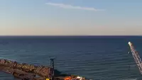 Widok z pylonu na plażę, latarnię morską i kanał portowy.