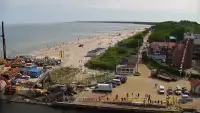 Widok z pylonu na plażę, latarnię morską i kanał portowy.