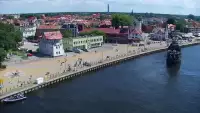 Widok z pylonu na plażę, latarnię morską i kanał portowy.