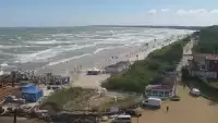 Widok z pylonu na plażę, latarnię morską i kanał portowy.