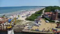 Widok z pylonu na plażę, latarnię morską i kanał portowy.