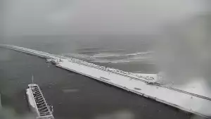 Widok z pylonu na plażę, latarnię morską i kanał portowy.