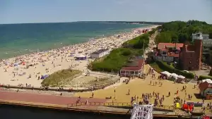Widok z pylonu na plażę, latarnię morską i kanał portowy.