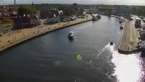 Widok z pylonu na plażę, latarnię morską i kanał portowy.