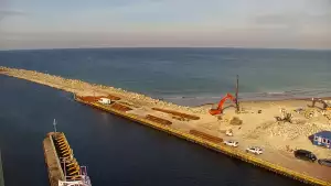 Widok z pylonu na plażę, latarnię morską i kanał portowy.