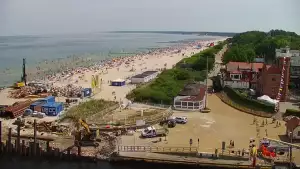 Widok z pylonu na plażę, latarnię morską i kanał portowy.