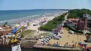 Widok z pylonu na plażę, latarnię morską i kanał portowy.