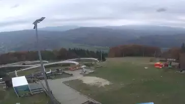 Obraz przedstawia tor saneczkowy wraz z piękną panorama.