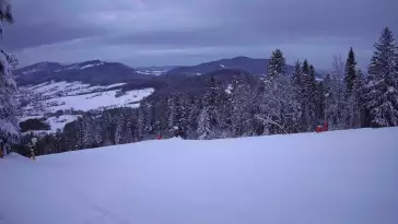 Widok na trasy narciarskie w Kasinie, gdzie czerwona trasa łączy się z niebieską.