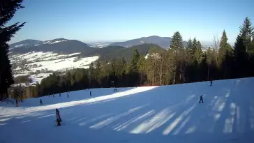 Widok na trasy narciarskie w Kasinie, gdzie czerwona trasa łączy się z niebieską.