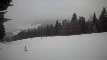 Widok na trasy narciarskie w Kasinie, gdzie czerwona trasa łączy się z niebieską.