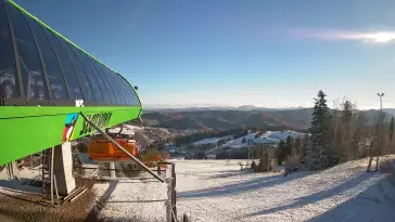Widok na stok narciarski i kolej z górnej stacji kompleksu Słotwiny Arena w Krynicy