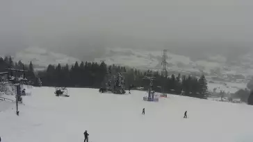 Widok na nowoczesną kolej krzesełkową i orczyk oraz część tras narciarskich