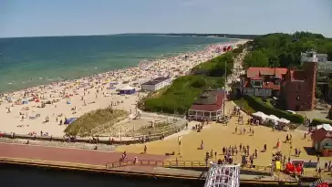 Widok z pylonu na plażę, latarnię morską i kanał portowy.