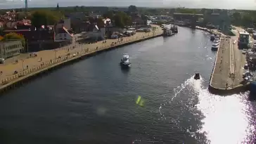 Widok z pylonu na plażę, latarnię morską i kanał portowy.