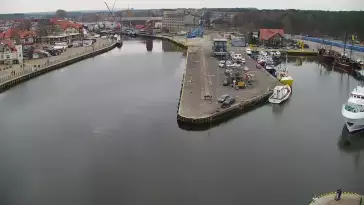 Widok z pylonu na plażę, latarnię morską i kanał portowy.