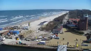 Widok z pylonu na plażę, latarnię morską i kanał portowy.