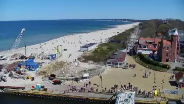Widok z pylonu na plażę, latarnię morską i kanał portowy.