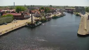 Widok z pylonu na plażę, latarnię morską i kanał portowy.