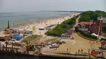 Widok z pylonu na plażę, latarnię morską i kanał portowy.