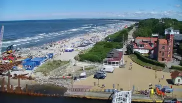 Widok z pylonu na plażę, latarnię morską i kanał portowy.