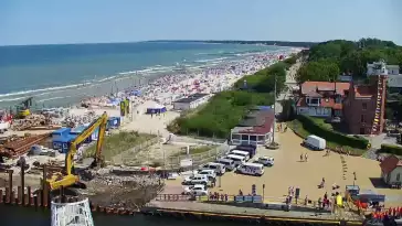 Widok z pylonu na plażę, latarnię morską i kanał portowy.