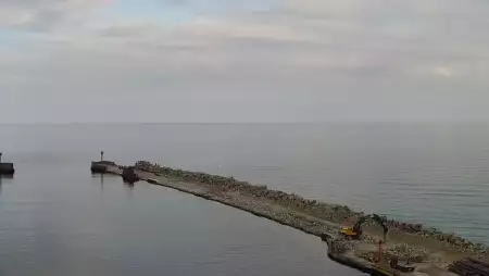 Widok z pylonu na plażę, latarnię morską i kanał portowy.