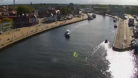 Widok z pylonu na plażę, latarnię morską i kanał portowy.