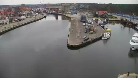 Widok z pylonu na plażę, latarnię morską i kanał portowy.