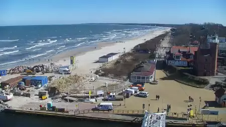 Widok z pylonu na plażę, latarnię morską i kanał portowy.