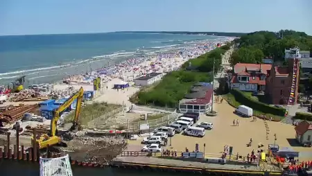 Widok z pylonu na plażę, latarnię morską i kanał portowy.