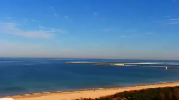 Kamery nad morzem na szeroką plażę i falochrony w Świnoujściu.