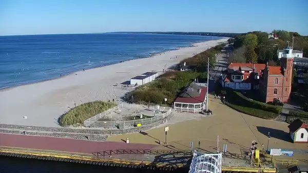 Widok z pylonu na plażę, latarnię morską i kanał portowy.