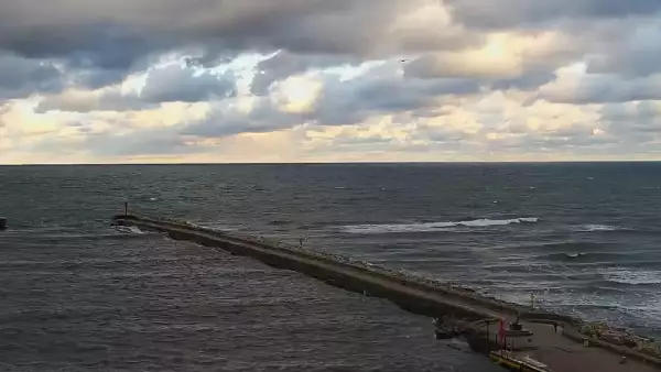 Widok z pylonu na plażę, latarnię morską i kanał portowy.