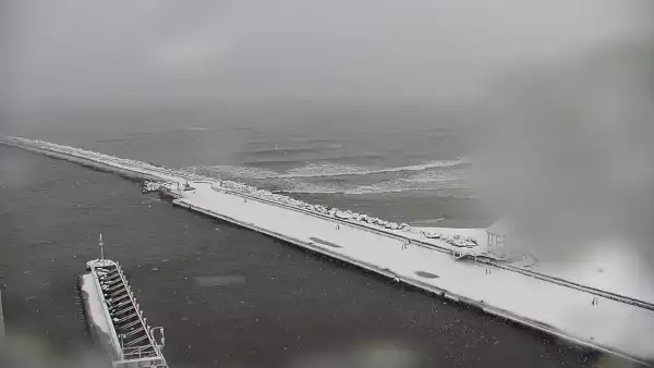 Widok z pylonu na plażę, latarnię morską i kanał portowy.