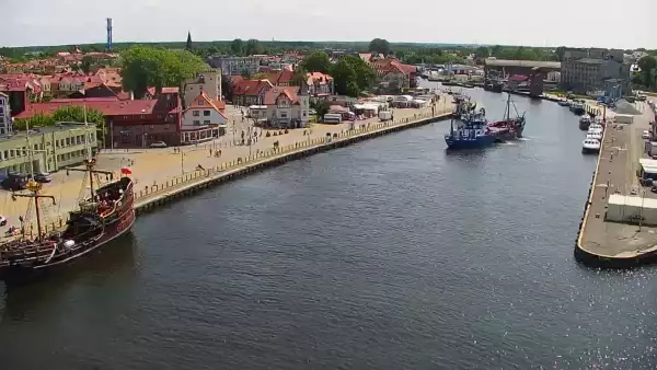 Widok z pylonu na plażę, latarnię morską i kanał portowy.