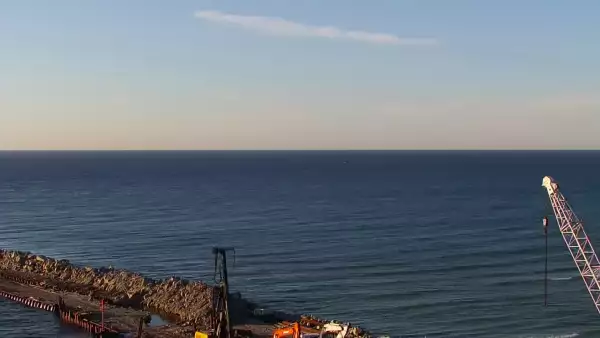 Widok z pylonu na plażę, latarnię morską i kanał portowy.