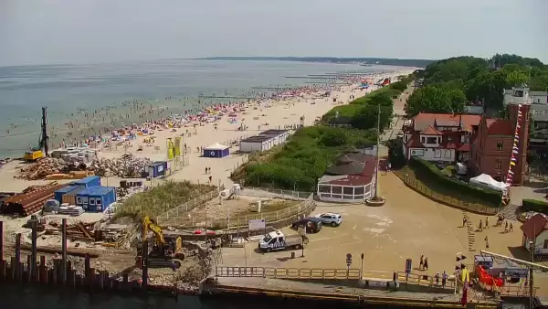 Widok z pylonu na plażę, latarnię morską i kanał portowy.