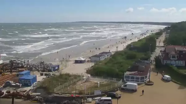 Widok z pylonu na plażę, latarnię morską i kanał portowy.