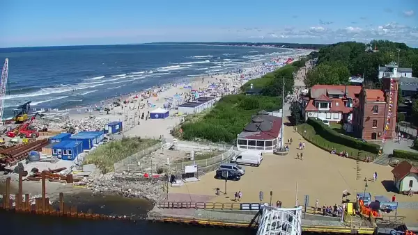 Widok z pylonu na plażę, latarnię morską i kanał portowy.