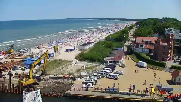 Widok z pylonu na plażę, latarnię morską i kanał portowy.