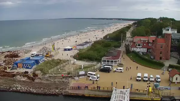 Widok z pylonu na plażę, latarnię morską i kanał portowy.