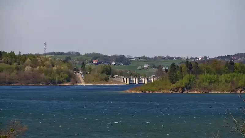 Widok z kamery ukazuje malowniczą linię brzegową, nad którą góruje charakterystyczna zapora w Świnnej Porębie