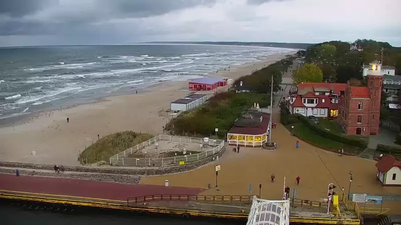 Widok z pylonu na plażę, latarnię morską i kanał portowy.