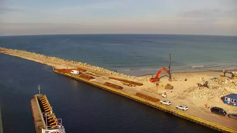 Widok z pylonu na plażę, latarnię morską i kanał portowy.