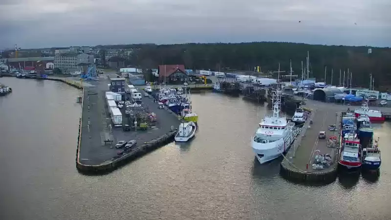 Widok z pylonu na plażę, latarnię morską i kanał portowy.
